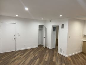 Los Angeles apartment for rent - a living room with white walls and wooden flooring and a door into a bathroom