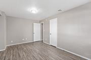 Norman apartment for rent - an empty living room with wood flooring and white walls at Emerald Greens, Norman, OK 73072