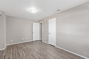 Norman apartment for rent - an empty living room with wood flooring and white walls at Emerald Greens, Norman, OK 73072