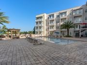 Jacksonville apartment for rent - a large swimming pool in front of an apartment building at Lake Lofts at Deerwood, Jacksonville, FL, 32216
