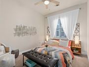 Jacksonville apartment for rent - a bedroom with a bed and a window and a ceiling fan at Lake Lofts at Deerwood, Jacksonville, FL, 32216
