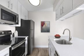 Orlando apartment for rent - a kitchen with black appliances and white cabinets at Lakeside Villas, Florida