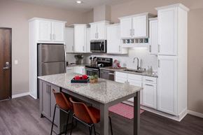 Hopkins apartment for rent - a kitchen with white cabinets and a granite counter top