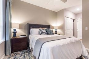 Brooklyn Park apartment for rent - a bedroom with a bed and a ceiling fan