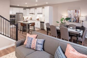 Maple Grove apartment for rent - A modern living room with a grey couch and a dining table set up.
