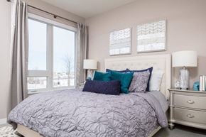 Maple Grove apartment for rent - a bedroom with a large window and a bed with gray and blue bedding
