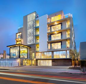 Los Angeles apartment for rent - A modern building with a glass facade and a lit up balcony.
