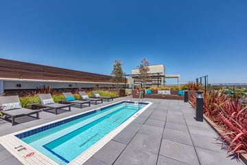 Los Angeles apartment for rent - A pool surrounded by lounge chairs and plants.