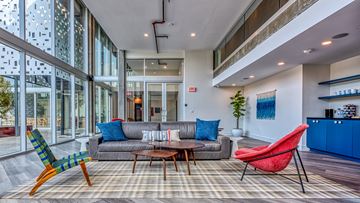 Los Angeles apartment for rent - A living room with a grey couch, a red chair and a blue chair.