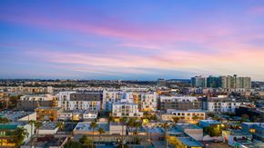 Los Angeles apartment for rent - A cityscape at dusk with buildings illuminated and a clear sky.