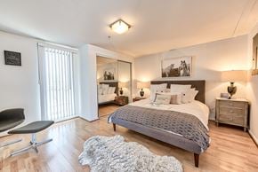 Los Angeles apartment for rent - A bedroom with a bed, chair, and a rug.