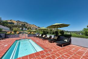 Los Angeles apartment for rent - A pool with a red brick floor and a yellow umbrella.