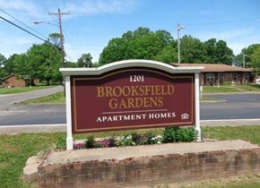 Westmoreland apartment for rent - A sign for Brookfield Gardens Apartment Homes is displayed in front of a brick wall.