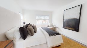 San Francisco townhouse for rent - A bedroom with a white bed and a large painting on the wall.