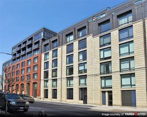 Brooklyn apartment for rent - a large building with cars parked in front of it