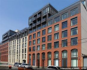 Brooklyn apartment for rent - a tall brick building with cars parked in front of it