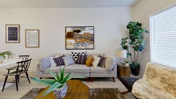 Ogden apartment for rent - a living room with a couch and a table with a plant