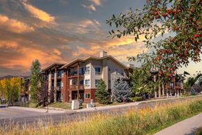 Steamboat Springs apartment for rent - A modern apartment building with a street in front and trees around.