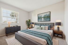 Oakland Park apartment for rent - A bedroom with a large bed, a nightstand with a lamp, and a painting on the wall.