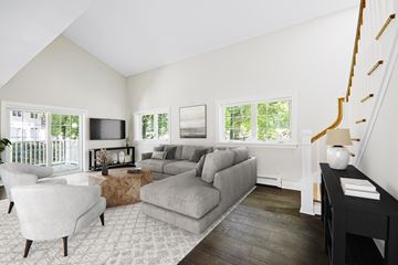 Greenwich triplex for rent - A living room with a grey couch and a white chair.