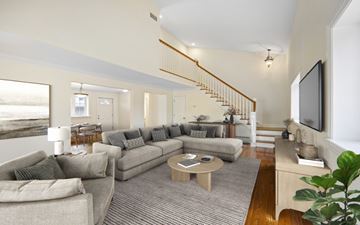 Greenwich triplex for rent - A living room with a grey couch and a wooden coffee table.