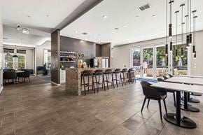 Newberry apartment for rent - Community lounge with granite island, bar seating, tables, and patio doors at The Flats at Tioga Town Center.