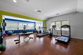 Exton apartment for rent - A spacious fitness center with beautiful hardwood flooring, large windows, cardio and weight equipment, a filtered water station, and large windows.