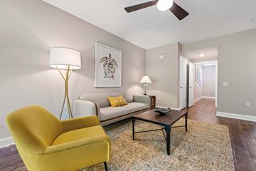 Exton apartment for rent - A yellow chair sits in a living room with a couch and a lamp.