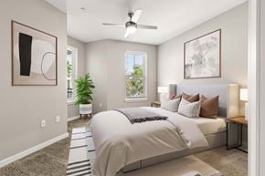 Newberry apartment for rent - Bedroom at The Flats at Tioga Town Center with bed, bedside lamps, ceiling fan, and plant.