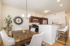 Granger apartment for rent - Kitchen and dining room view with dining table and chairs, and bar stools at The Residences at Toscana Park, Granger, IN
