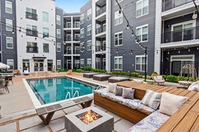 Olivette apartment for rent - A modern apartment complex with a pool and outdoor seating area.