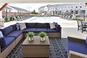 St. Peters townhouse for rent - the outdoor lounge area of a resort pool with blue couches and tables
