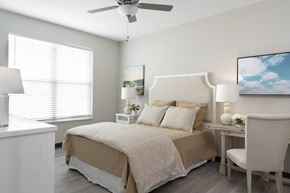 Shiloh apartment for rent - The Oasis at Hartman Lakes main bedroom with light planking flooring, ceiling fan and large window