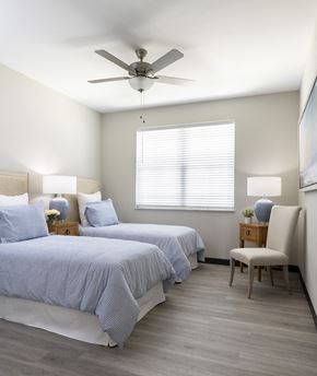 Shiloh apartment for rent - The Oasis at Hartman Lakes guest bedroom with light plank flooring, ceiling fan and large window