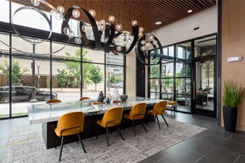 Community dining area with statement chandelier and marble table