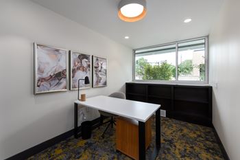 Private office with desk and abstract wall art