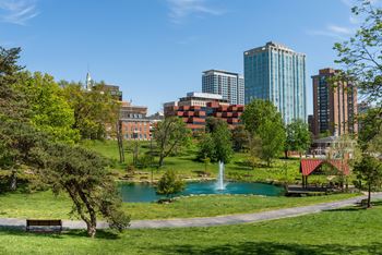 Urban park with pond fountain and city skyline