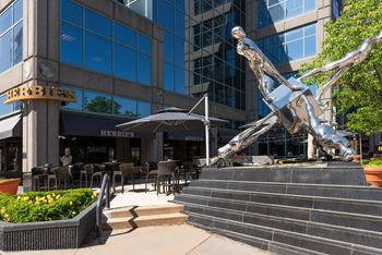 Polished metal sculpture outside modern building entrance