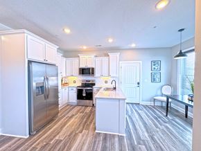 Sedalia apartment for rent - A kitchen with a refrigerator, microwave, oven, and sink.