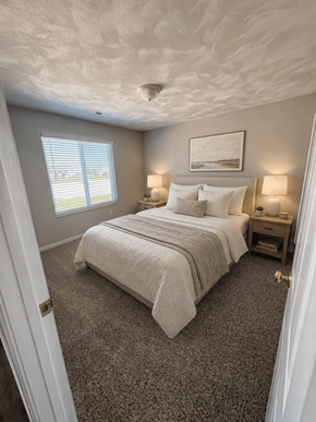 Swansea townhouse for rent - A bedroom with a bed, nightstands, and a window.