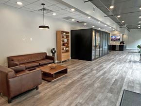 Saint Louis apartment for rent - A modern office space with a brown leather sofa and a wooden coffee table.