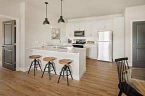 Valley Park apartment for rent - a kitchen with white cabinets and a bar with three stools at 44 West Luxury Living, Missouri