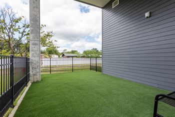 Covered patio with artificial turf and metal railing