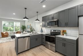 Ellisville apartment for rent - Modern kitchen with gray cabinets and white countertops at Mila Apartments, Missouri
