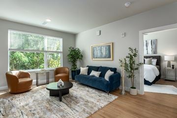 Ellisville apartment for rent - A living room with a blue couch and a painting on the wall.