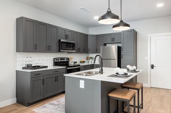 Kitchen with gray cabinetry and white countertops