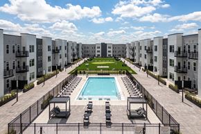 Ellisville apartment for rent - Courtyard pool with lounge chairs and lawn area at Mila Apartments, Ellisville, Missouri