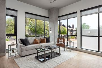 Clayton apartment for rent - a living room with a couch and a table in front of large windows
