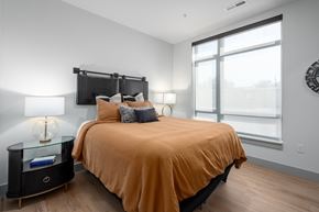 Clayton apartment for rent - Bedroom with large windows and orange bedding at Bemiston Place Apartments, Clayton, 63105