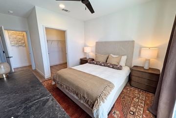 Rogers apartment for rent - A bedroom with a large bed and a rug on the floor.